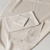 Beige towel set with 'MOKU' branding on a light gray background