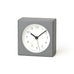 Gray square clock with a white face on a white background