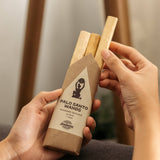 Person holding a package of Palo Santo Wands with a blurred background
