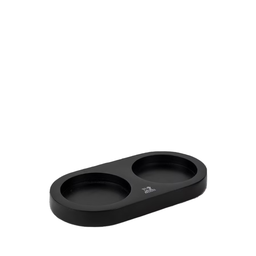 Black tray with two round cutouts for spice mills on a white background