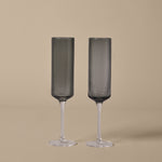 Two ribbed champagne flutes on a beige background