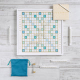 Scrabble board game set on a wooden surface with tiles and bags.