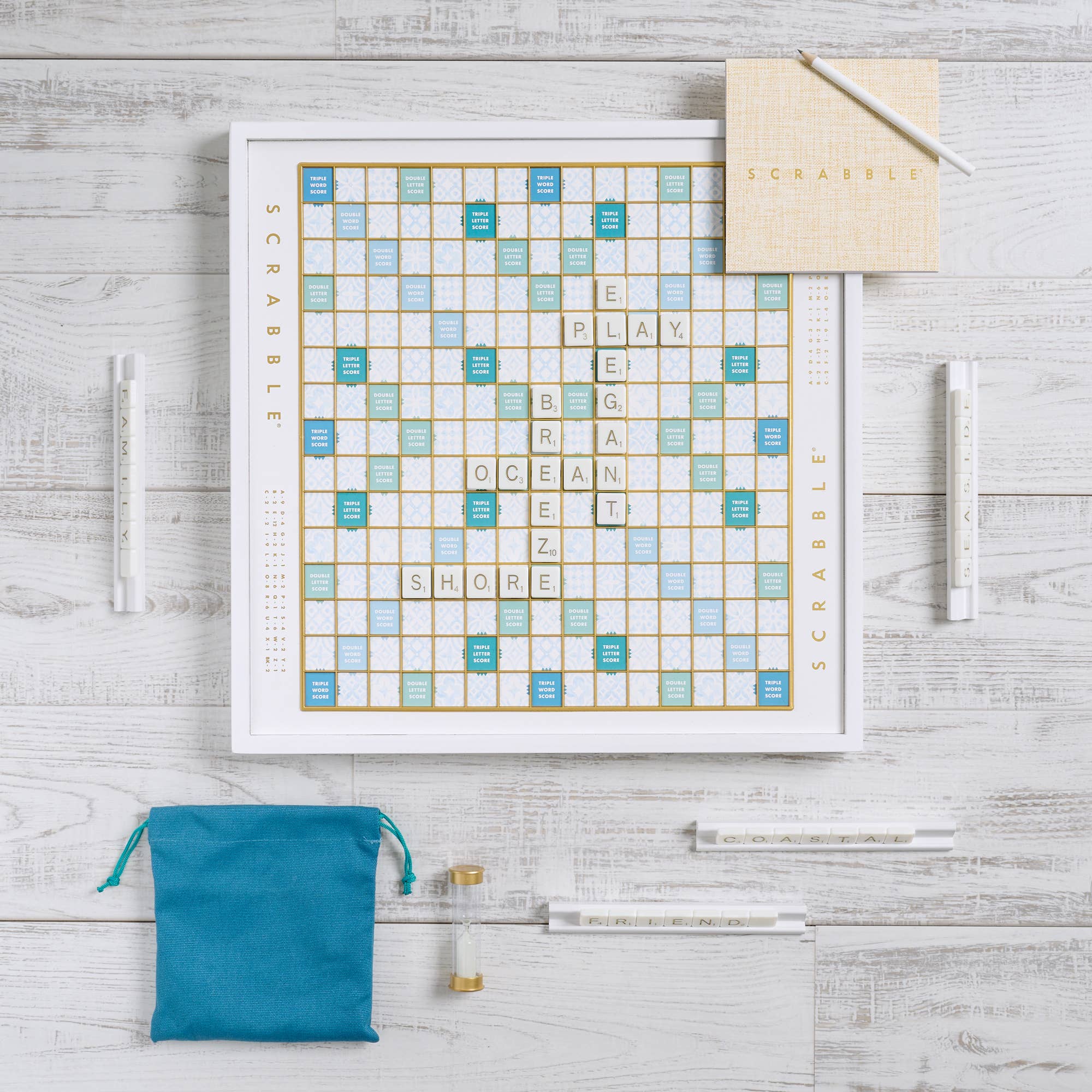 Scrabble board game set on a wooden surface with tiles and bags.