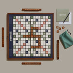 Scrabble board game set with tiles and accessories on a beige surface