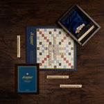 Scrabble board game set on a wooden surface with Scrabble pieces and box.