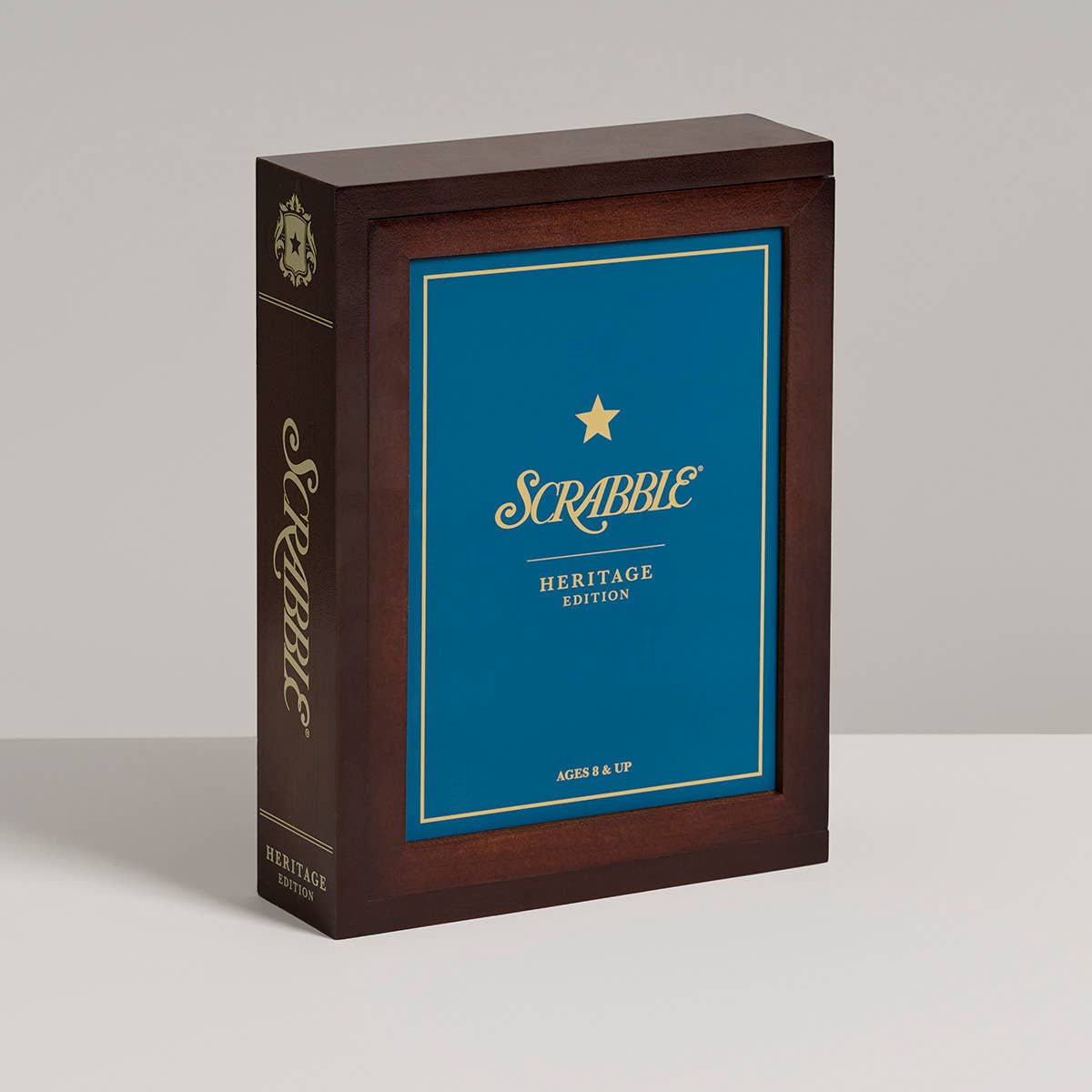 Scrabble Heritage Edition packaging with wooden box and blue face on a gray background
