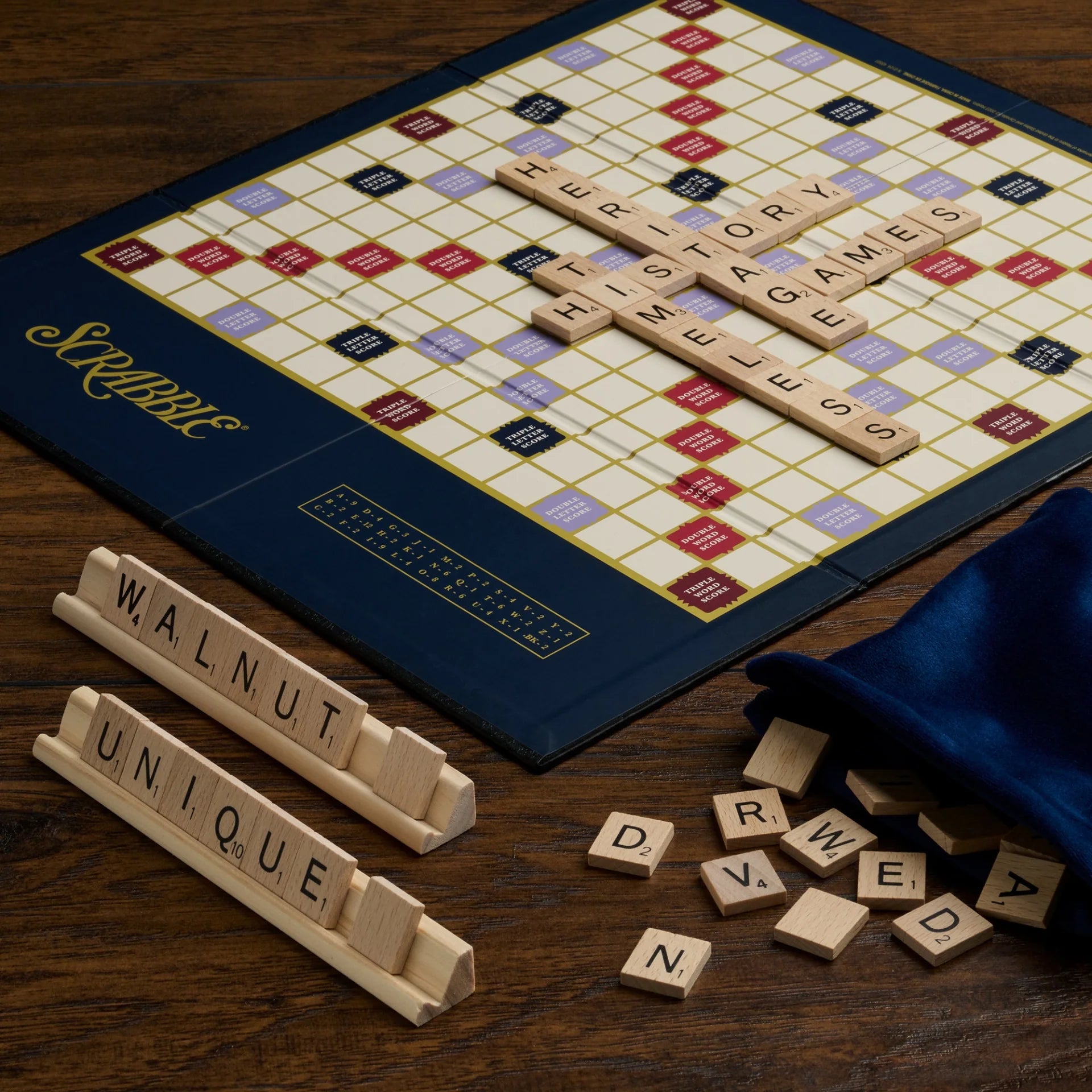 Scrabble board game with tiles and pieces on a wooden surface