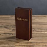 Brown wood Scrabble Travel Edition game box on a wooden surface with a dark gray background