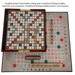 Scrabble Deluxe Travel Edition game board on top of a traditional folding Scrabble board for size comparison.
