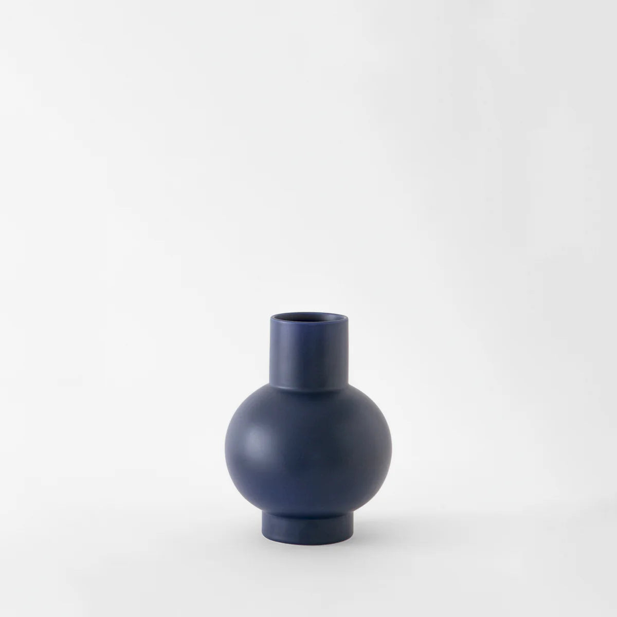 Small navy blue vase on a white background