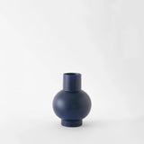 Small navy blue vase on a white background