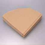 Stack of v shaped brown paper coffee filters on a gray background
