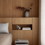 Wooden headboard with a vase, books, and lamp on a neutral background