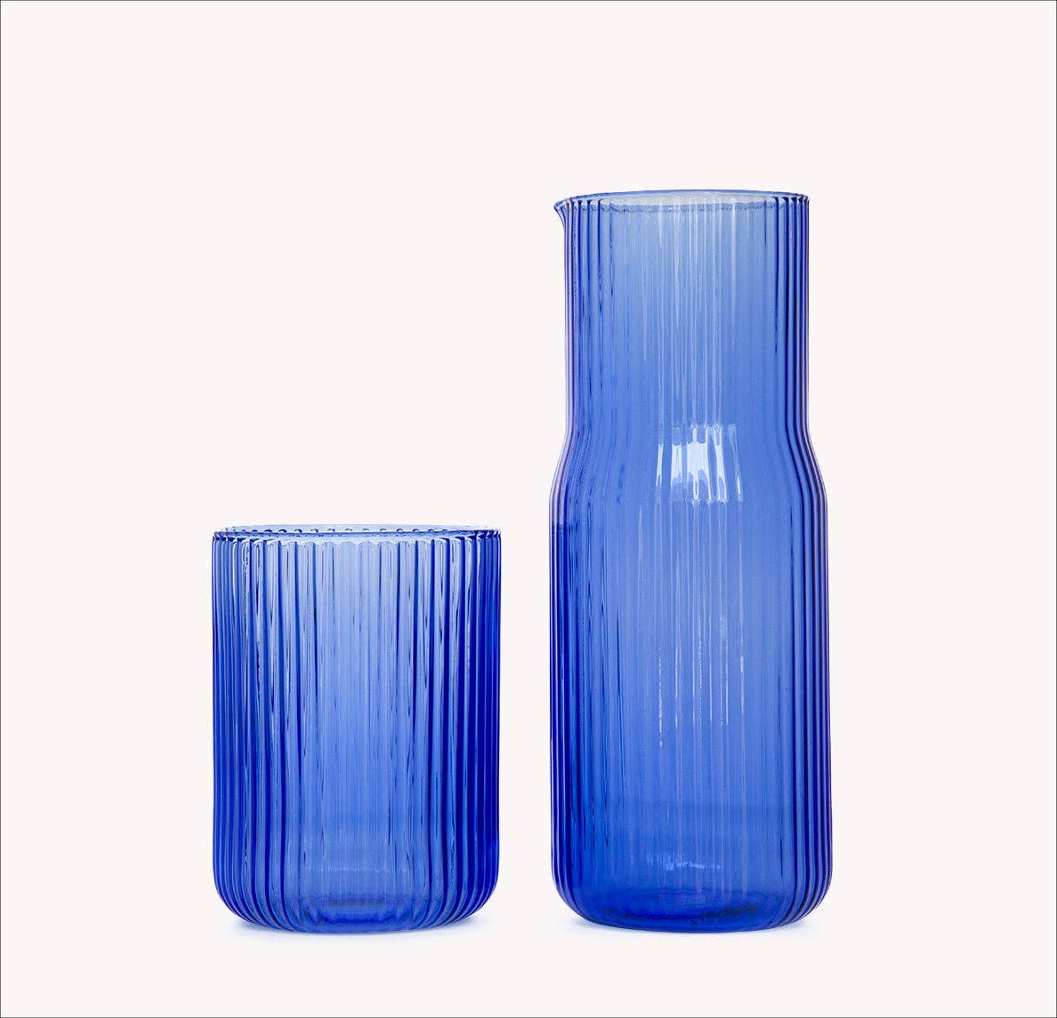 Ripple blue glass water carafe and cup on white background