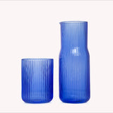 Ripple blue glass water carafe and cup on white background