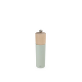 salt mill with wooden top and light green body on a white background