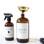 Two labeled brown bottles, one with funnel in opening, on a white background
