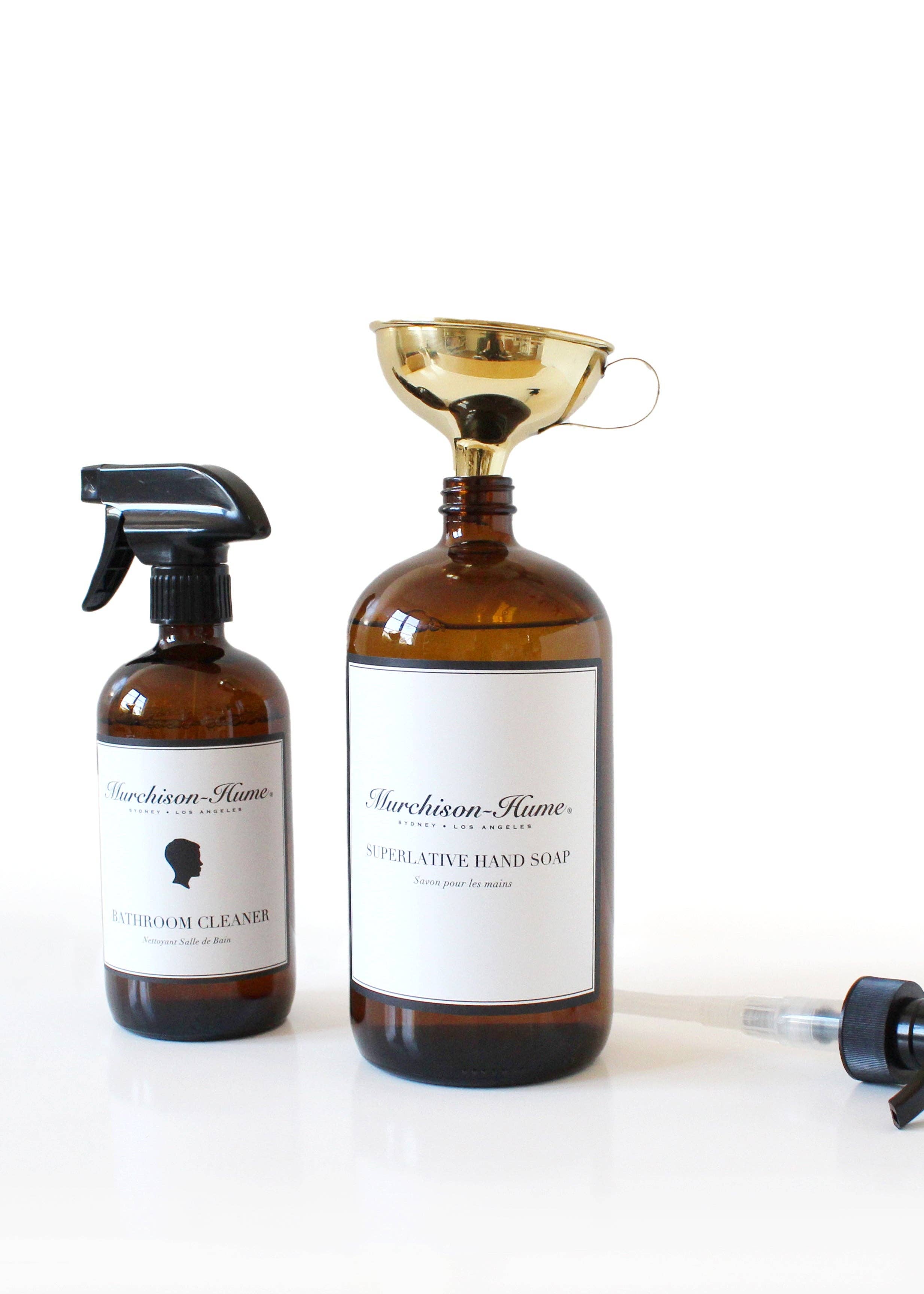 Two labeled brown bottles, one with funnel in opening, on a white background