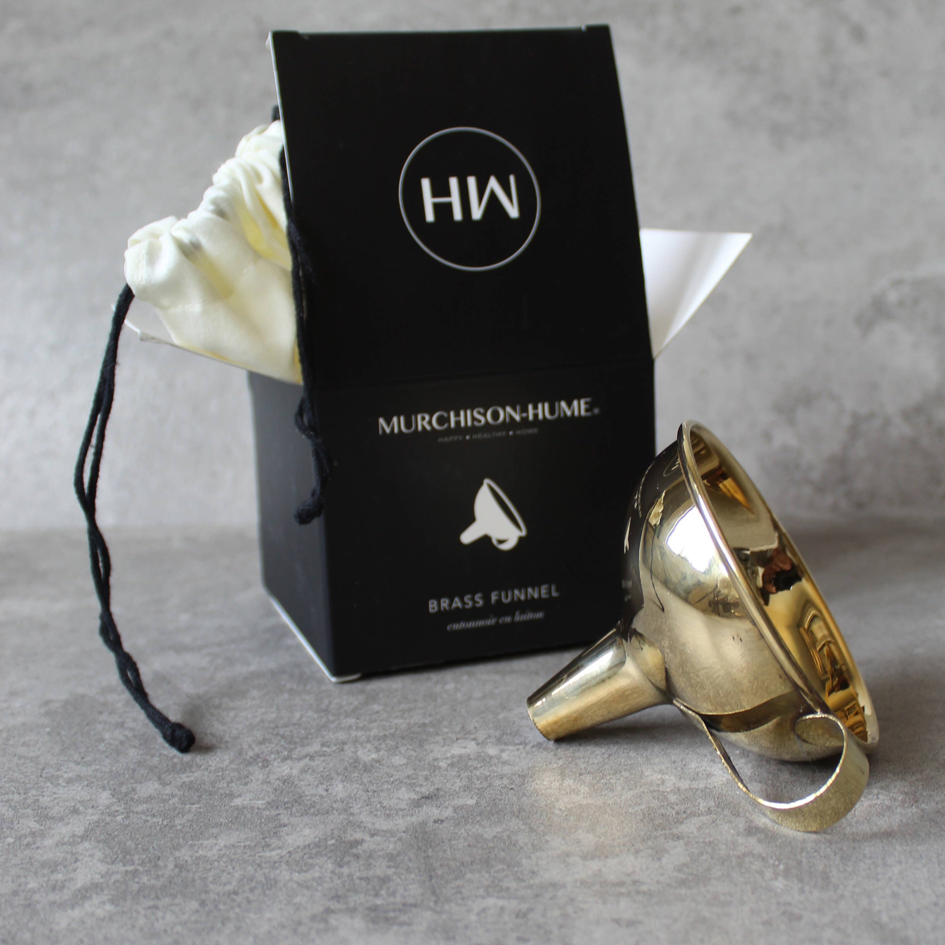 Gold brass funnel with Murchison-Hume box on a gray surface