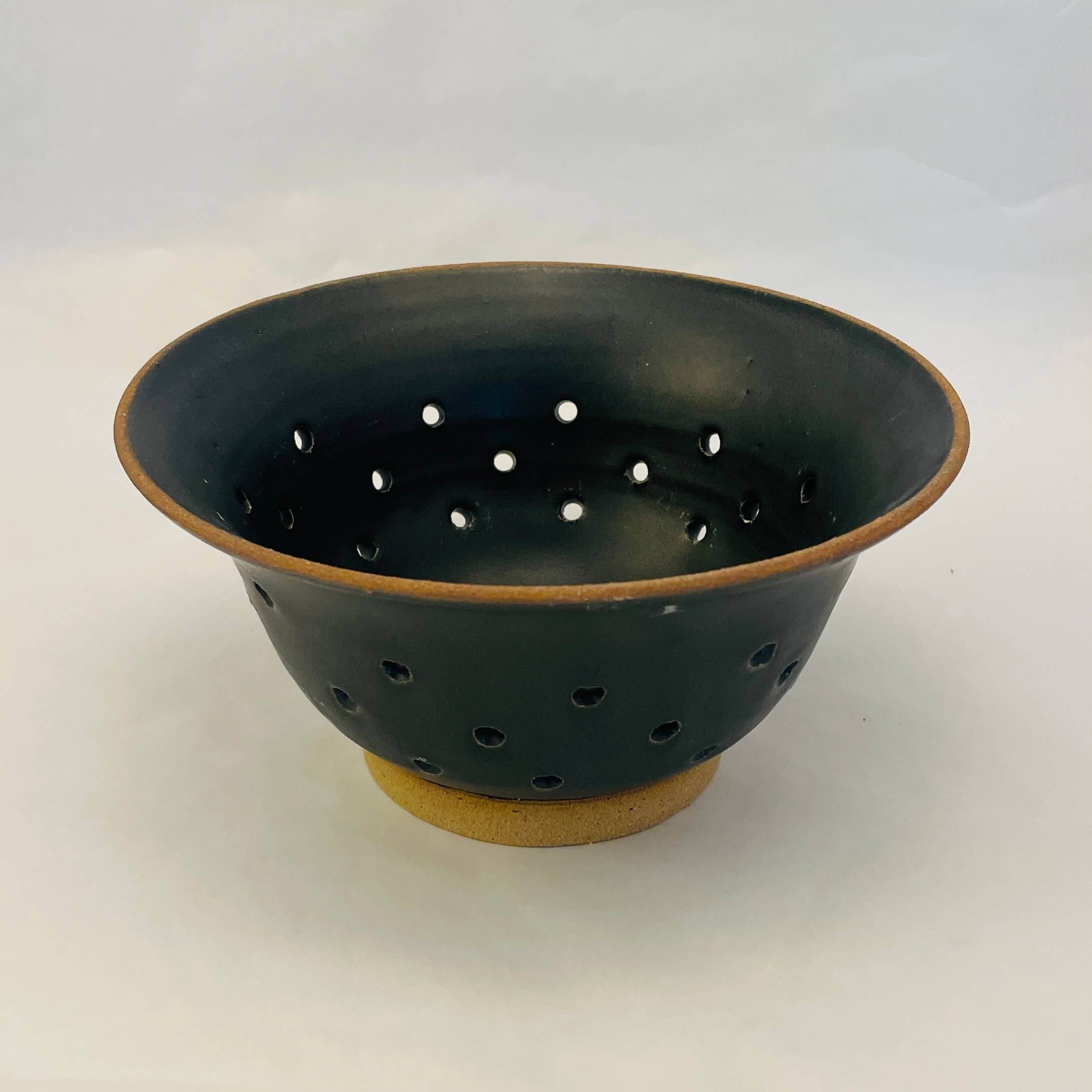 Black ceramic colander with flared opening and drainage holes, perfect for fresh fruit, made in Washington.