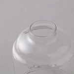 Clear glass vase on a light gray background