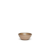 A tiny rounded ceramic bowl in a warm pale brown color featuring iron speckles and an unglazed rim
