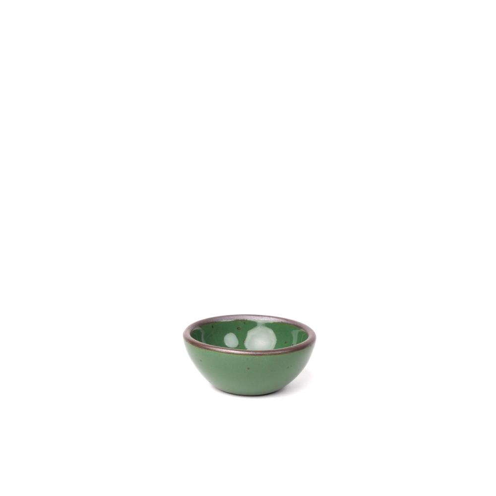 A tiny rounded ceramic bowl in a glossy emerald green color featuring iron speckles and an unglazed rim