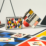 Colorful playing cards with geometric designs on a checkered surface