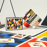 Colorful playing cards with geometric designs on a checkered surface