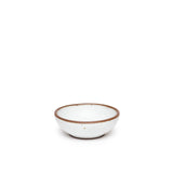 A small shallow ceramic bowl in a cool white color featuring iron speckles and an unglazed rim
