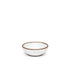 A small shallow ceramic bowl in a cool white color featuring iron speckles and an unglazed rim
