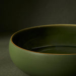 close up detail of green ceramic bowl on a dark background