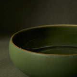 close up detail of green ceramic bowl on a dark background