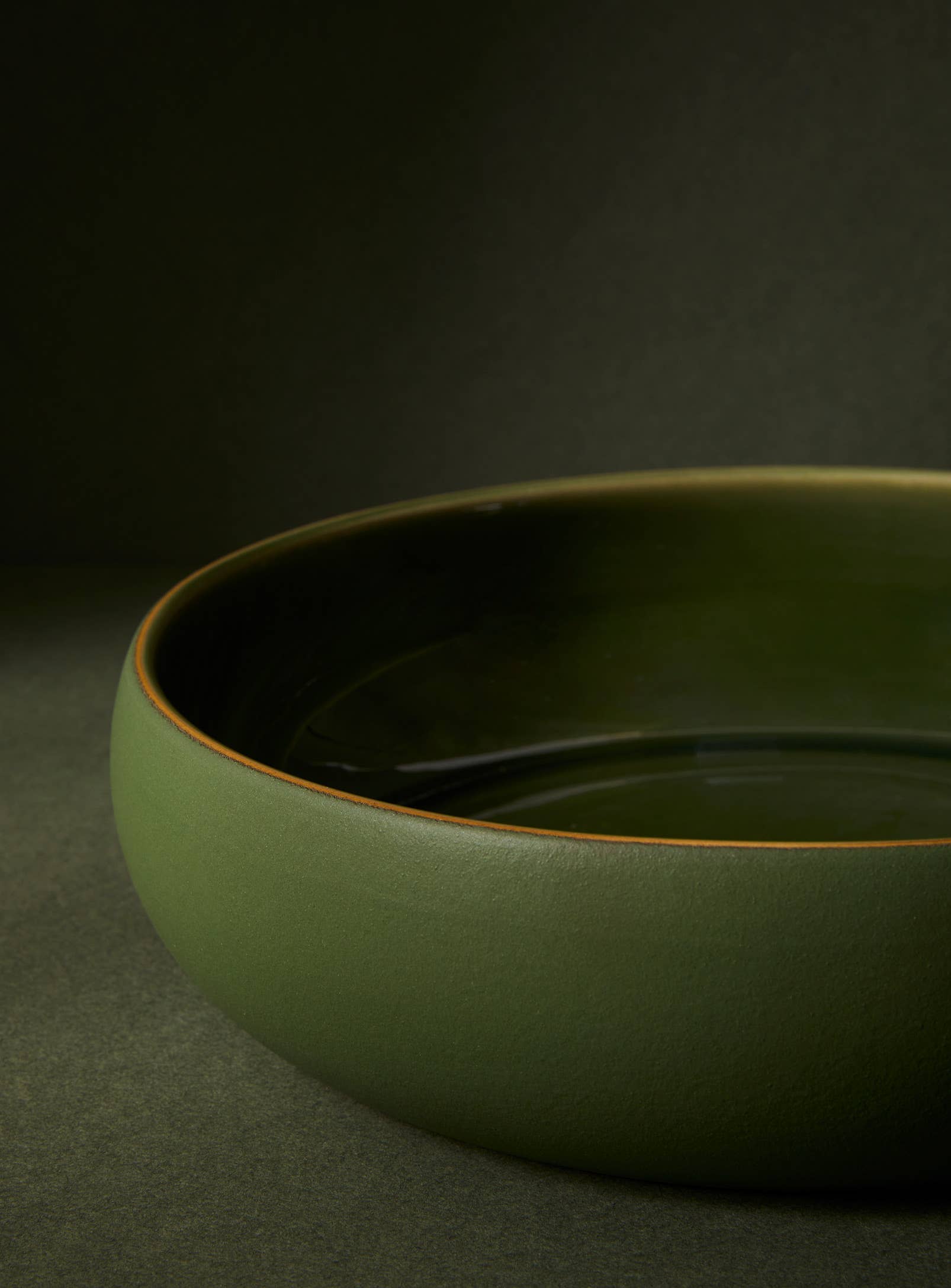 close up detail of green ceramic bowl on a dark background