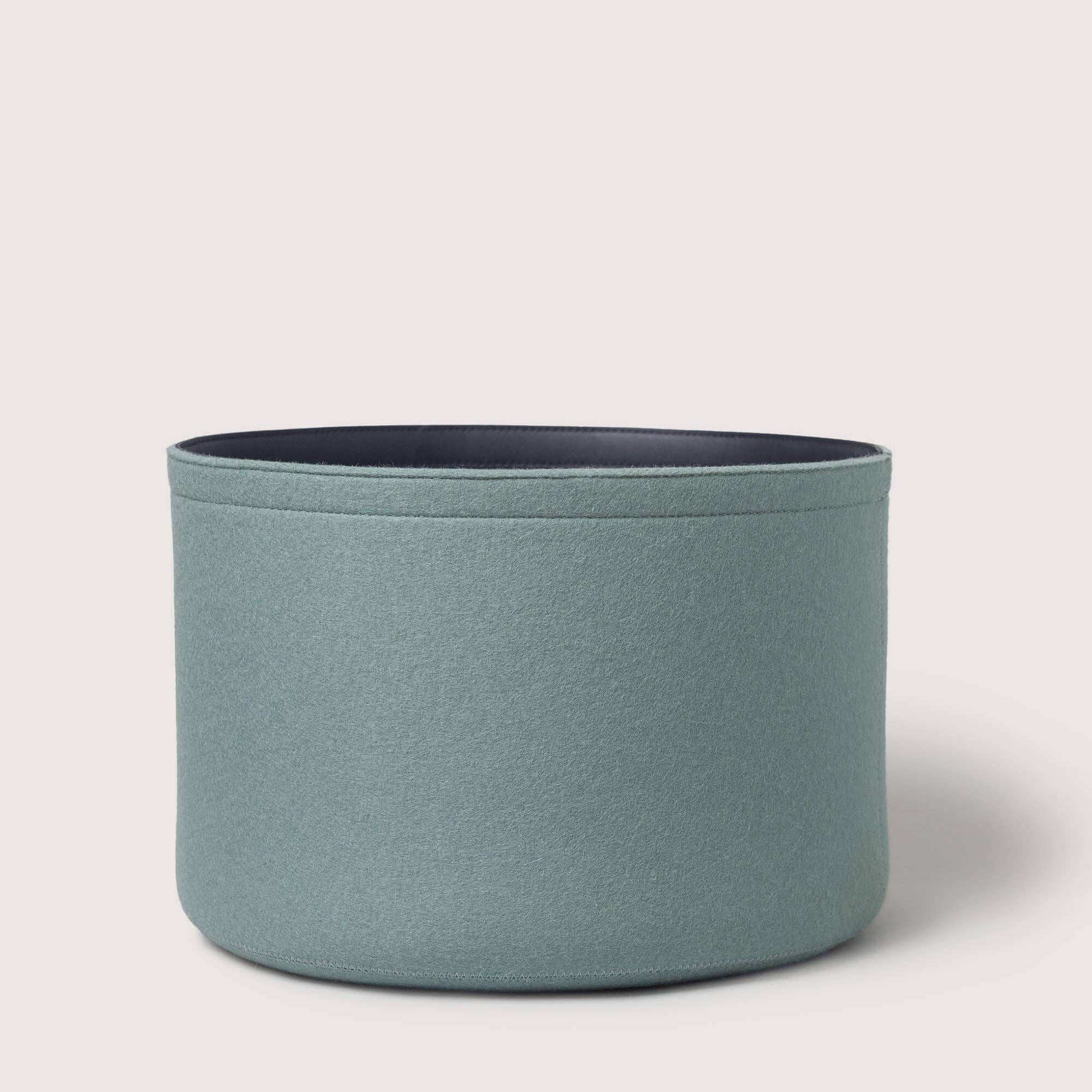 Blue cylindrical fabric basket on a light gray background