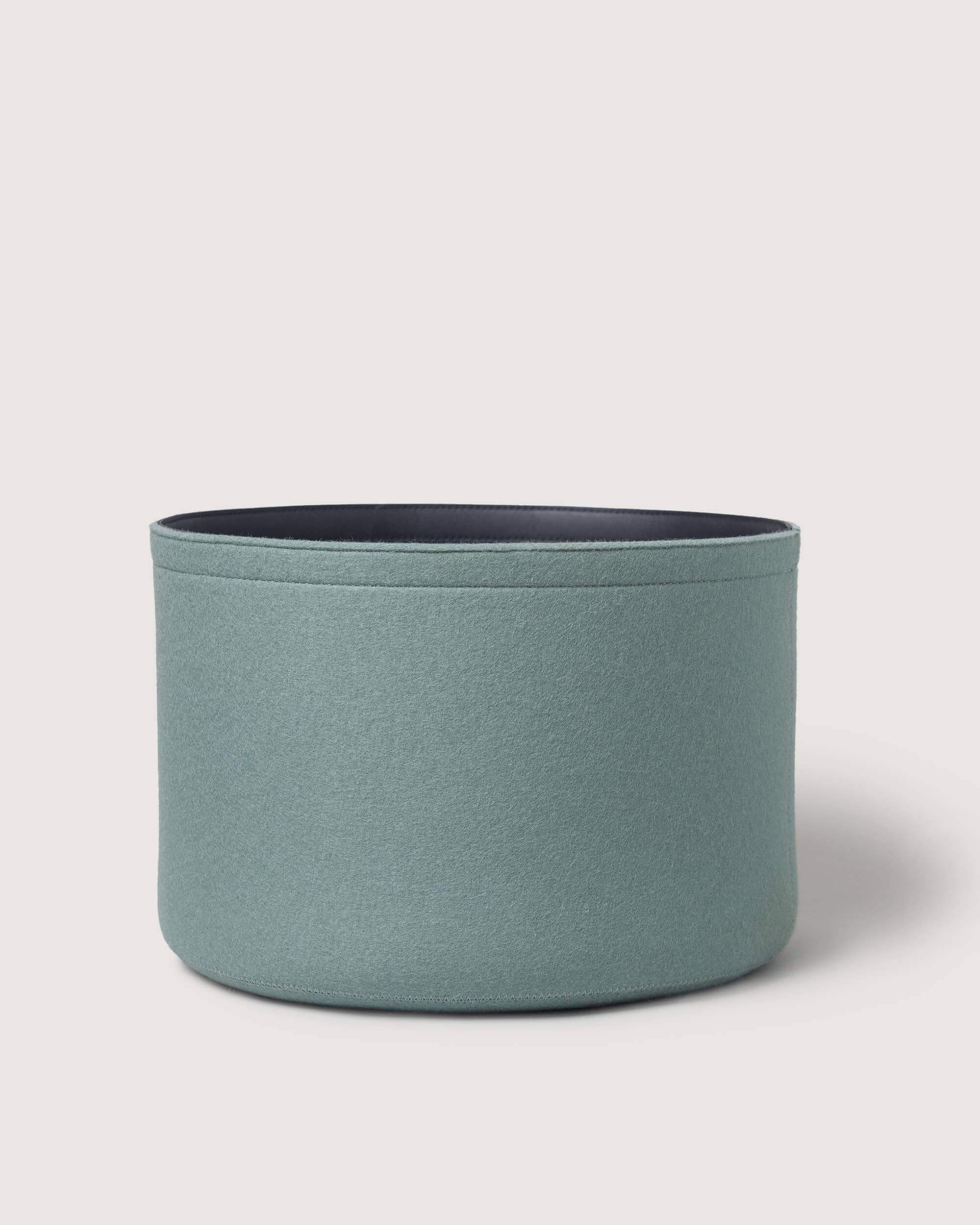 Blue cylindrical fabric basket on a light gray background
