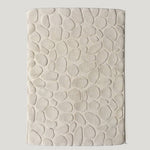 Textured beige bathmat on a light gray background