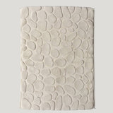 Textured beige bathmat on a light gray background