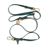 An adjustable, hunter green colored dog leash with brass lockable carabiners and rubber coated webbing.