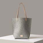 Gray tote bag with beige handle on a neutral background