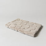 Folded beige textured mat on a light gray background