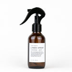 Brown linen spray bottle with black nozzle on a white background