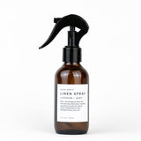 Brown linen spray bottle with black nozzle on a white background
