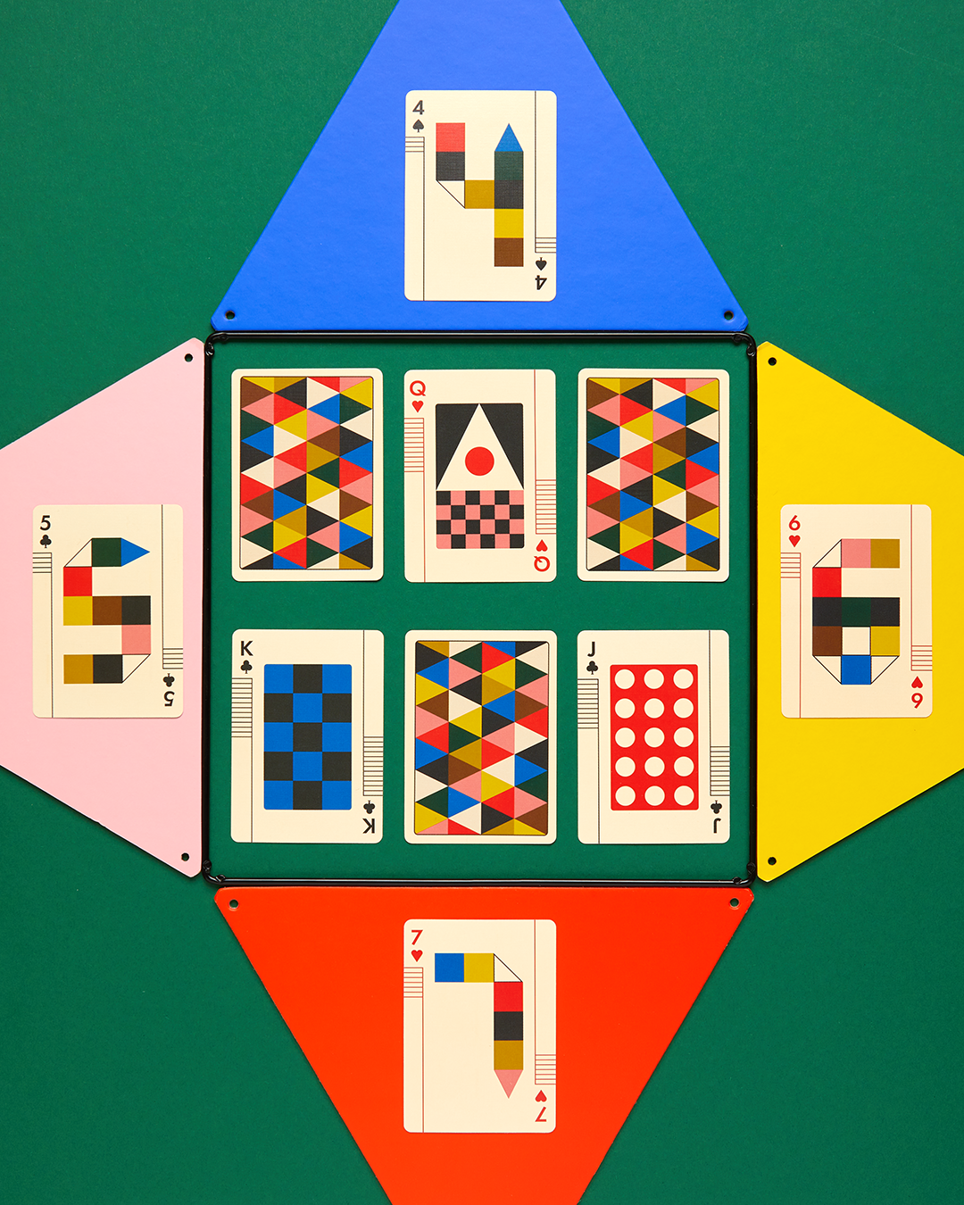Playing cards with colorful geometric patterns on a green background