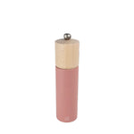 Pink pepper grinder with wooden top on a black background