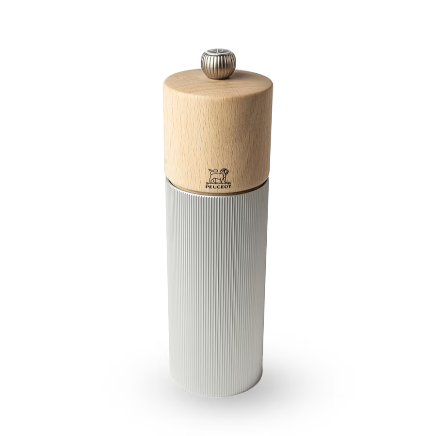 Pepper grinder with wooden top and ribbed metal body on a white background
