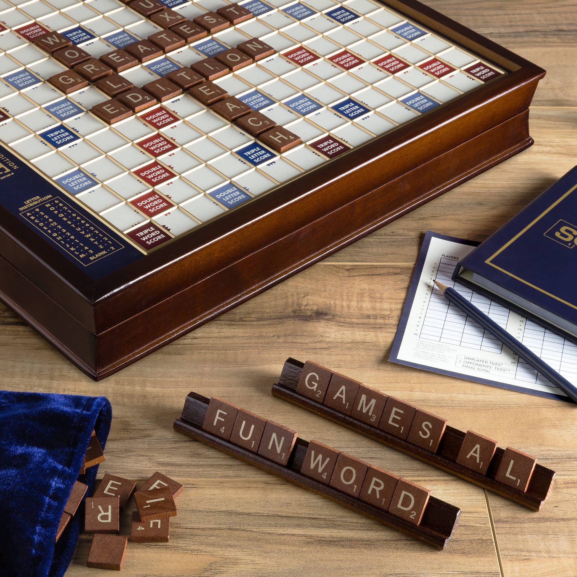 Wooden Scrabble board game set on a wooden surface with tiles and scorecard.