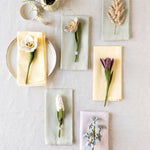Felt flowers displayed on napkins against a light beige tablecloth