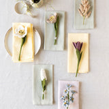 Felt flowers displayed on napkins against a light beige tablecloth