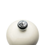 Top of white salt mill with a metallic cap featuring Peugeot lion logo on a white background